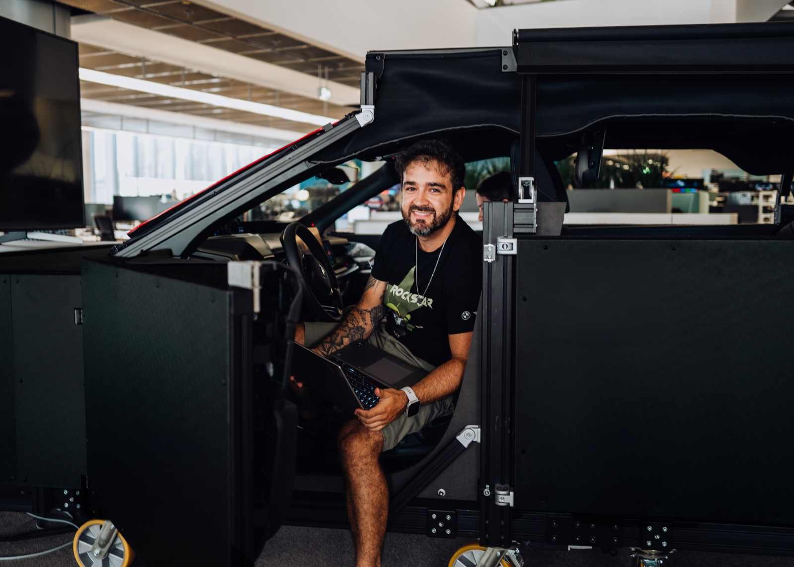 BMW software architect Matheus in a vehicle mockup at the research center