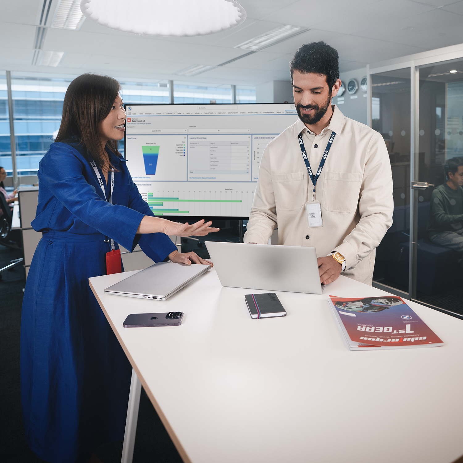 Two colleagues analyse data on a laptop.