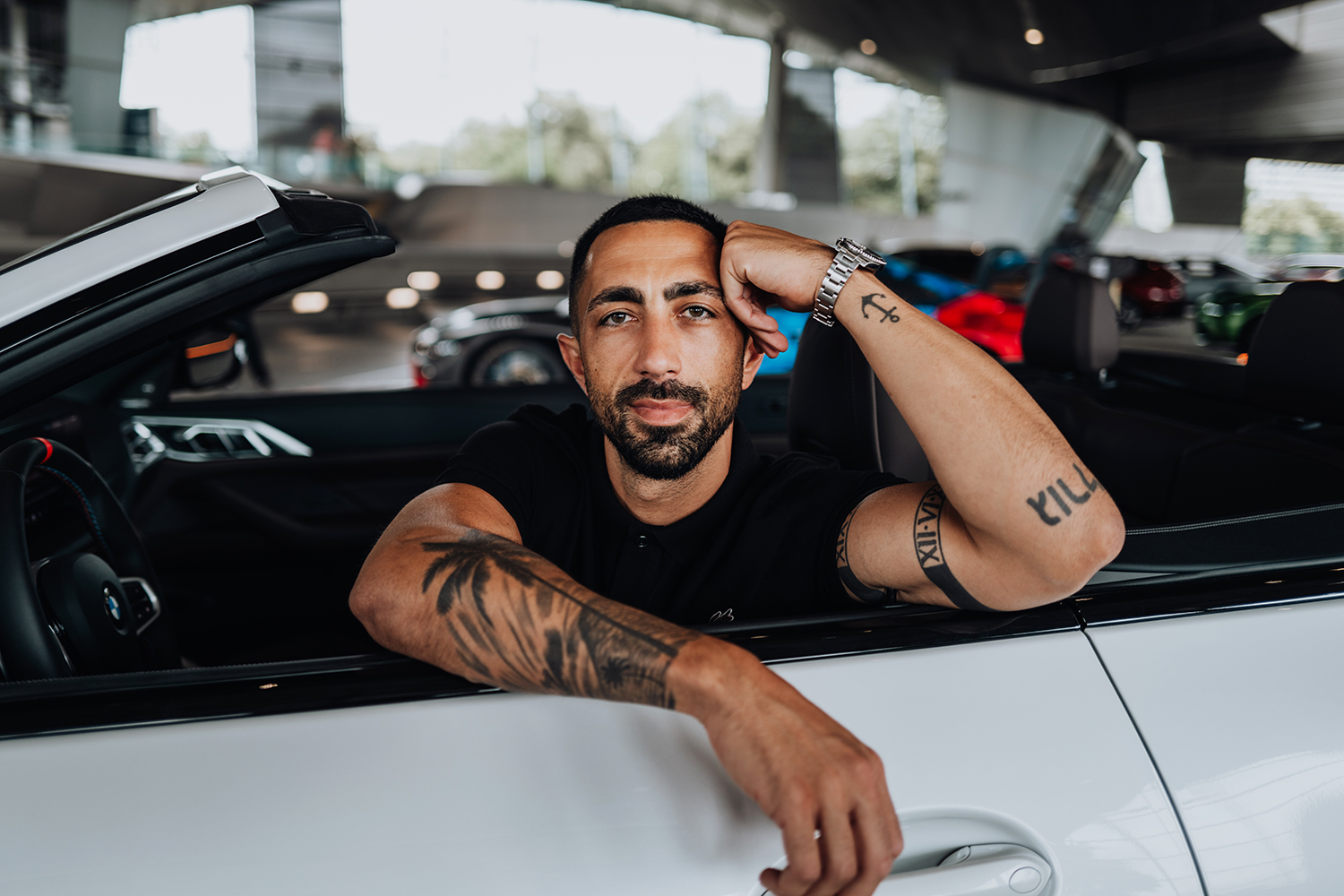 BMW Mitarbeiter Umut schaut lässig aus einem BMW M4 Cabrio