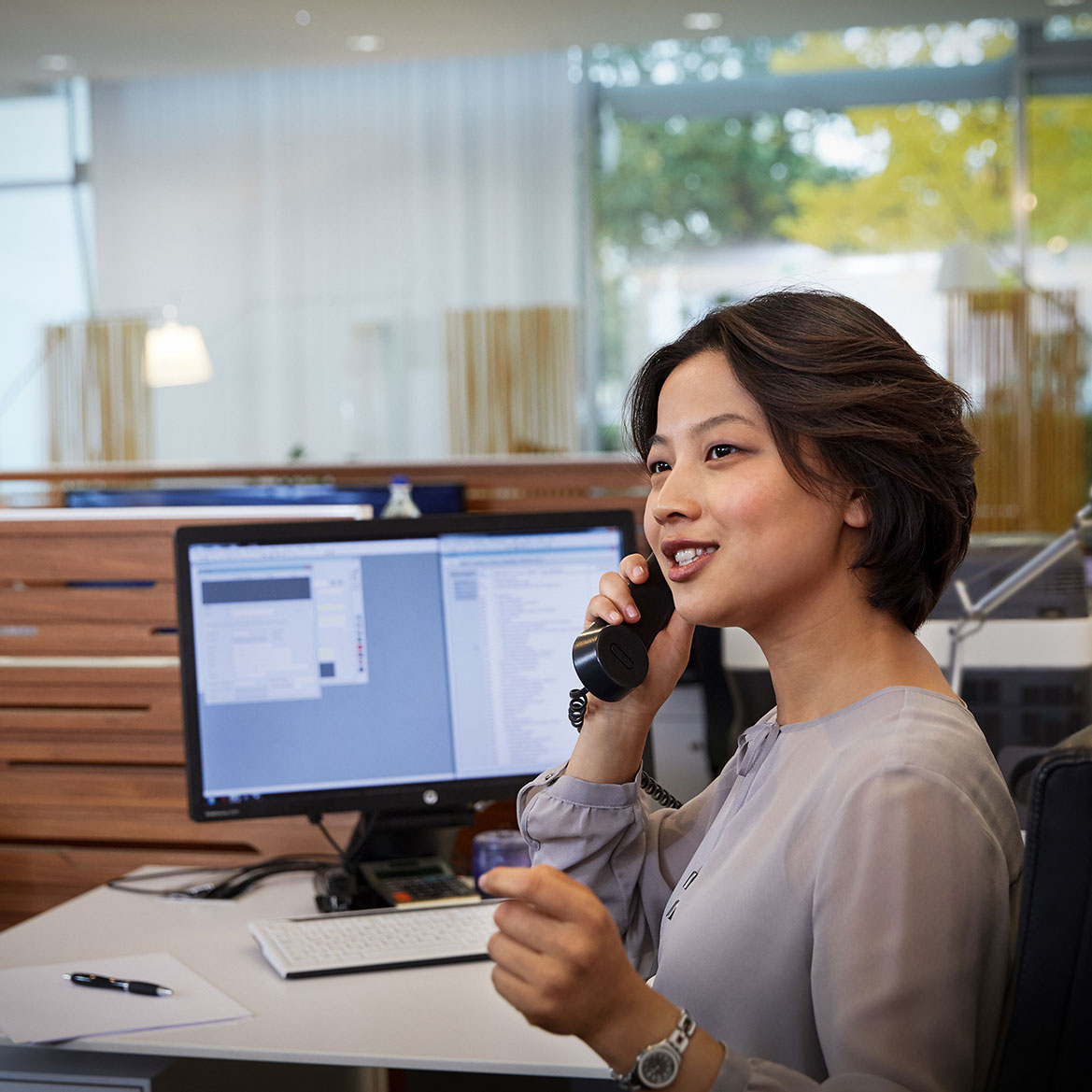 Mitarbeiterin bei BMW im Bereich Dienstleistungen und Bauwesen am Telefon.
