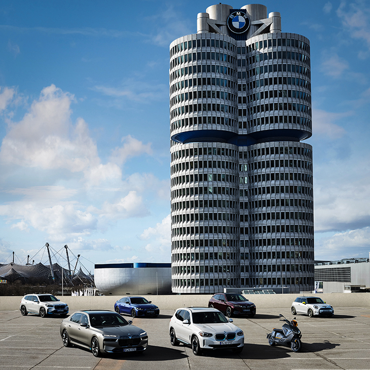 Das Bild zeigt die elektrifizierte BMW Group Flotte vor dem Vierzylinder.