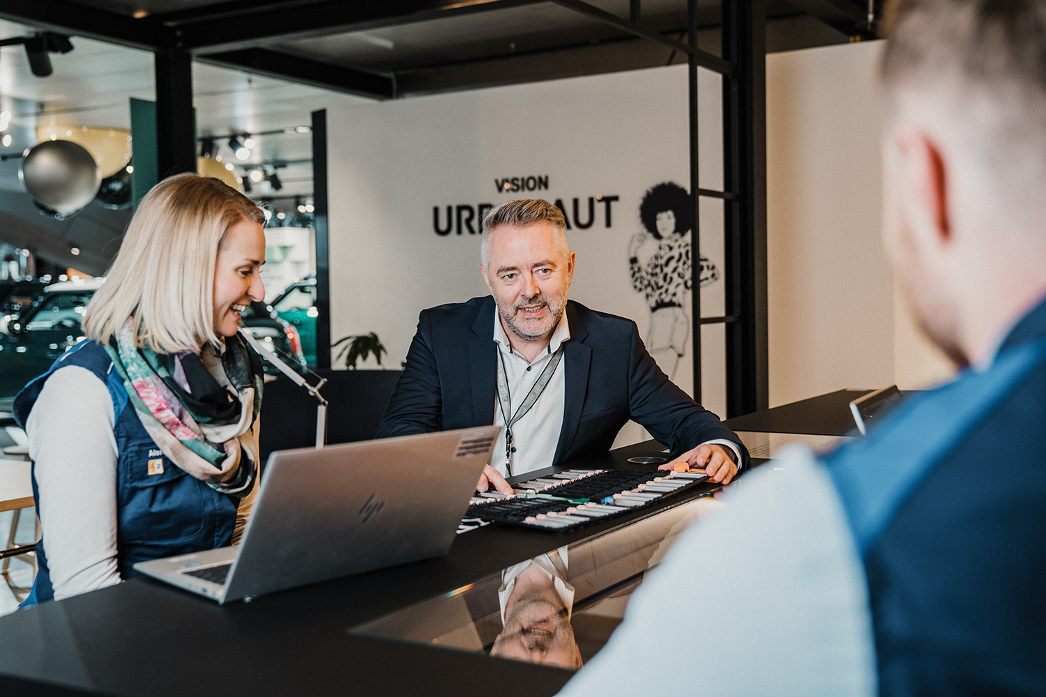Mitarbeiter im Gespräch mit Kunden in einem modernen Büro bei der BMW Group.