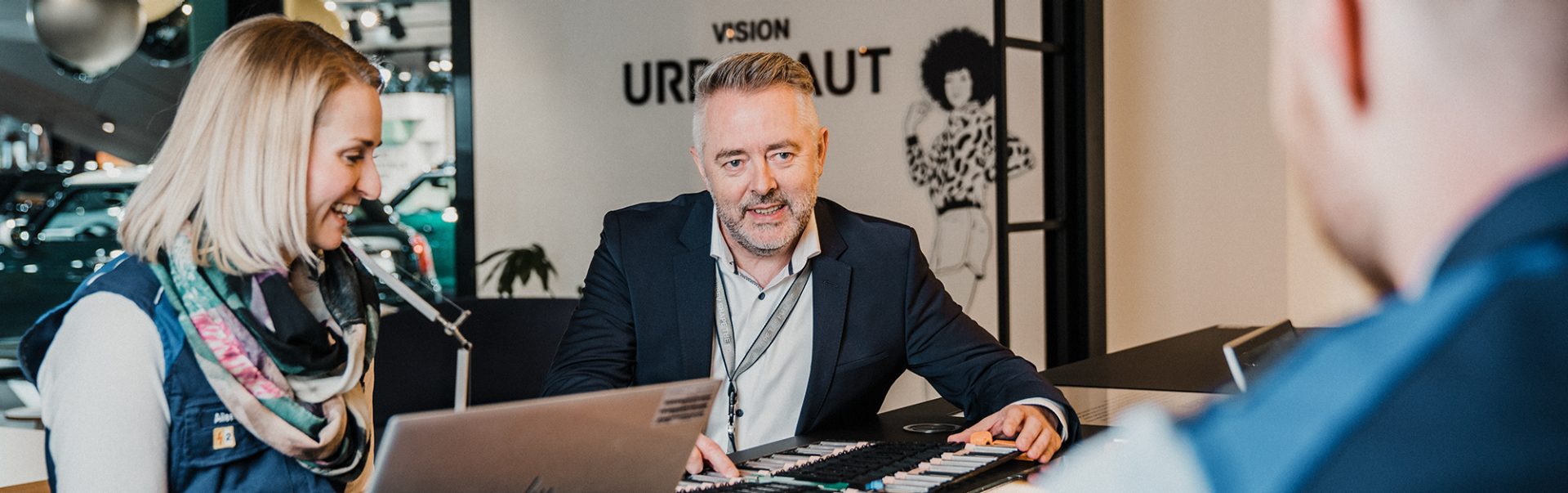 Mitarbeiter im Gespräch mit Kunden in einem modernen Büro bei der BMW Group.