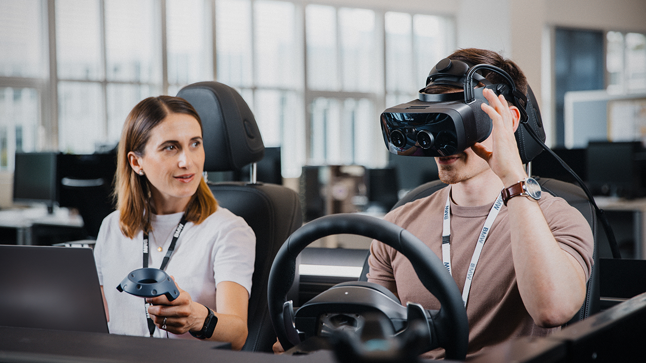 Zwei Kolleg:innen mit VR Brille in einem Designfahrzeug.