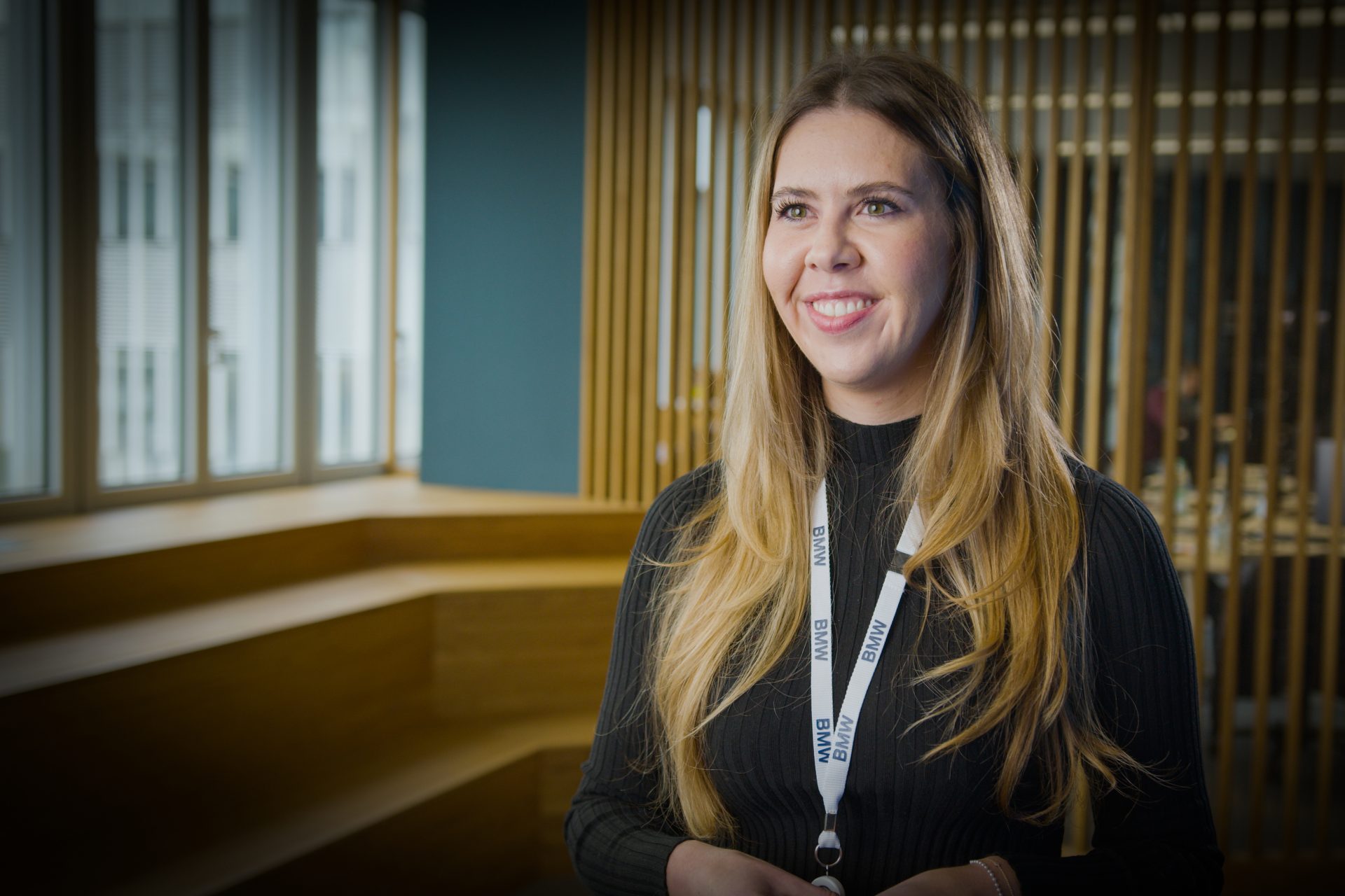 Eine Mitarbeiterin im Bereich IT lächelt in die Kamera.