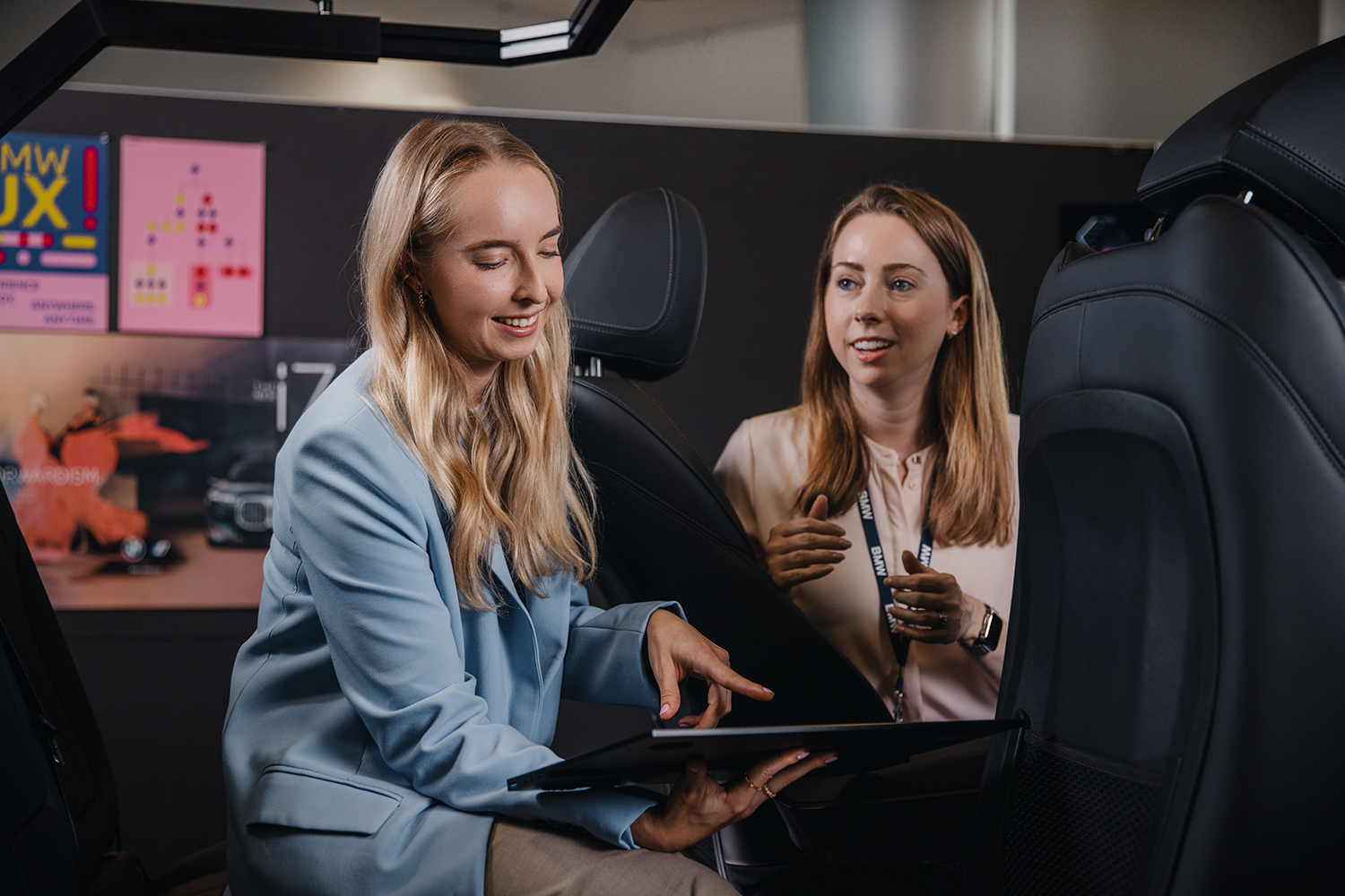 Two colleagues working with a tablet in a car setup