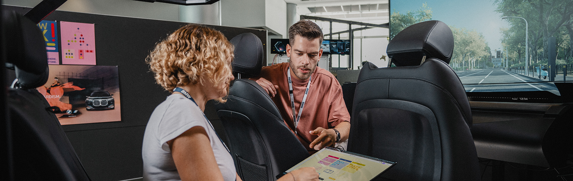 Zwei Kolleg:innen arbeiten im Interior eines Fahrsimulators