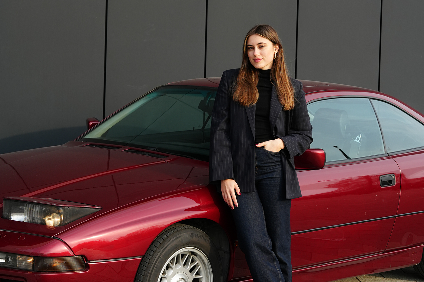 Rechtsreferendarin Sonja vor ihrem roten BMW Oldtimer