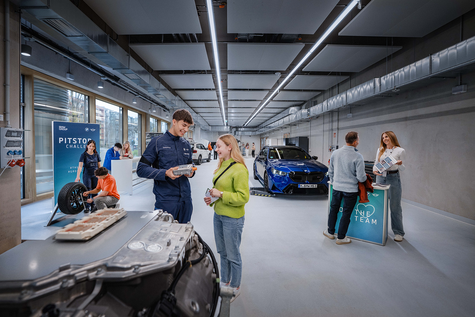  Jugendliche erkunden berufliche Möglichkeiten bei BMW in einer modernen Werkstatt.