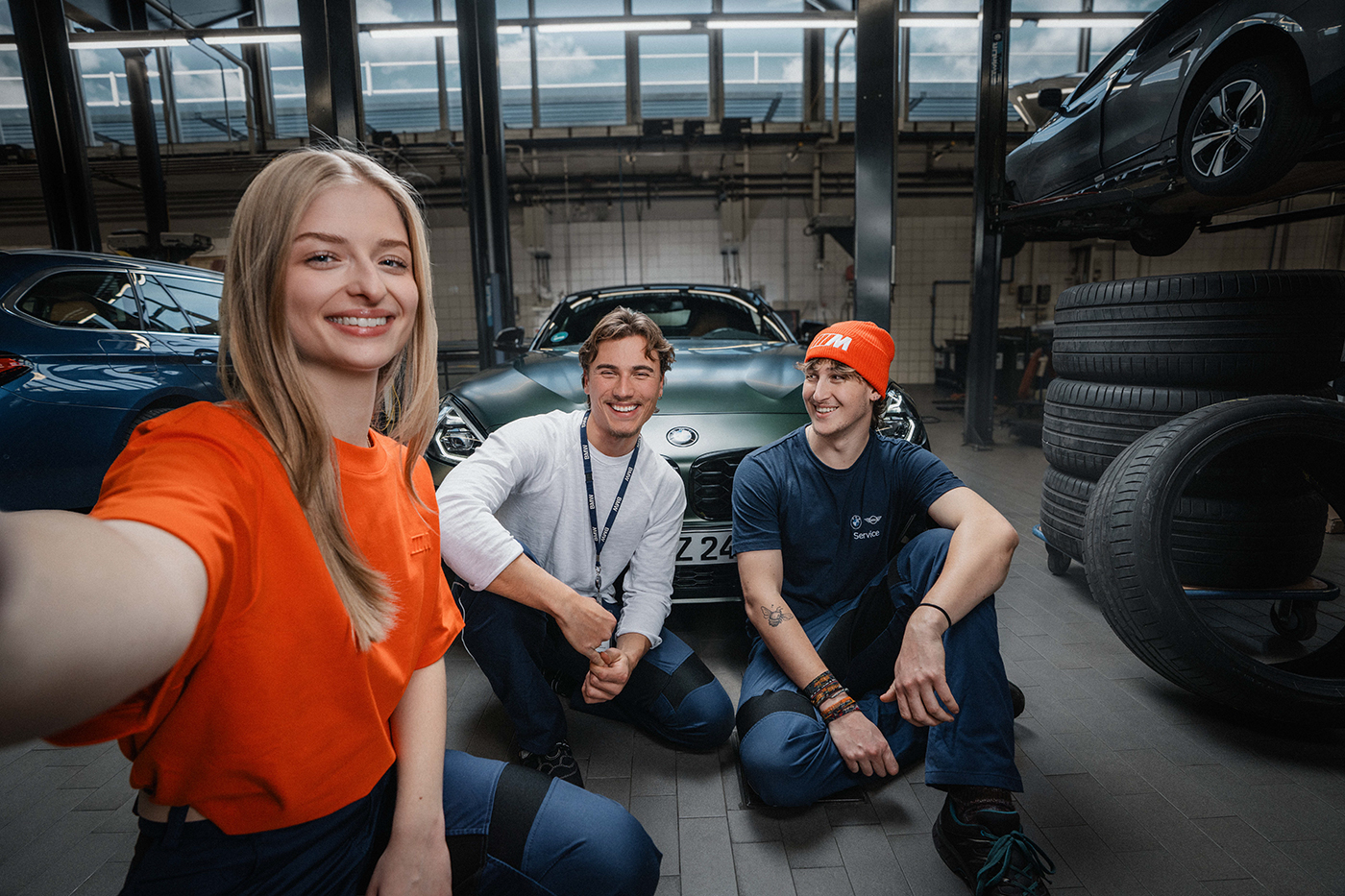 Drei Azubis machen ein Selfie in einer Kfz-Werkstatt