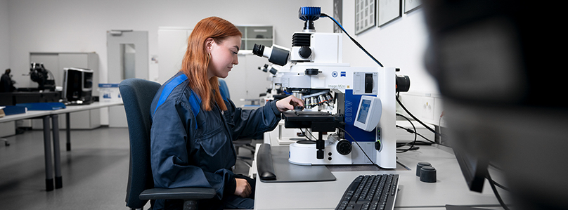 Laborumgebung mit einer Werkstoffprüferin der BMW Group, die Materialien analysiert.