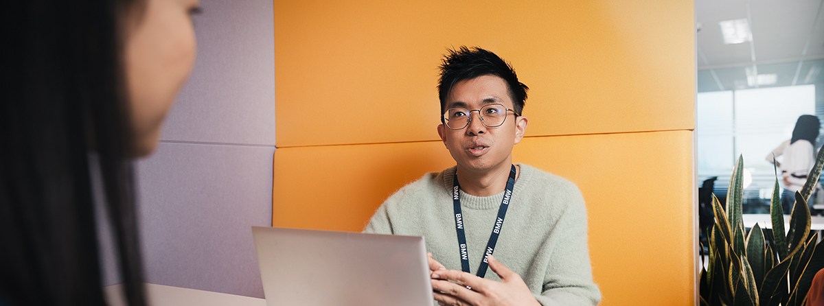 Ein Student bei BMW im Gespräch mit einer Kollegin.