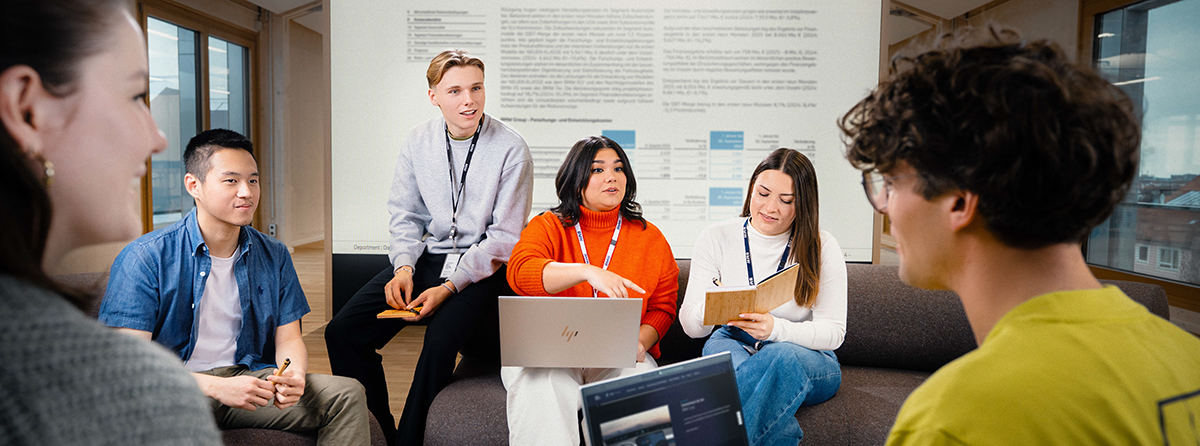 Sechs BMW Group Mitarbeitende unterhalten sich in einem modernen Office Setting.
