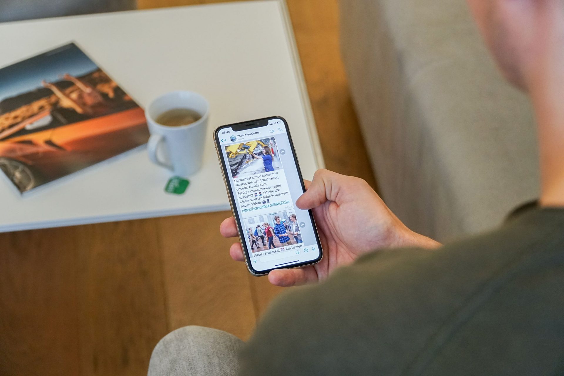 Nahaufnahme einer Hand, die ein Smartphone hält und Nachrichten anzeigt.