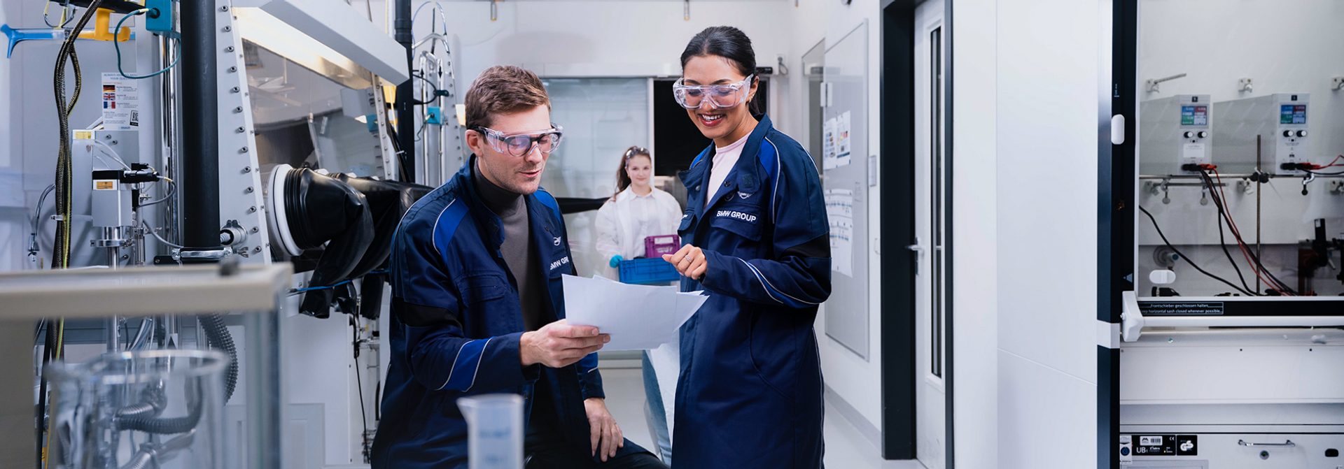 Eine Chemielaborantin-Auszubildende und ihr Ausbilder arbeiten im Labor
