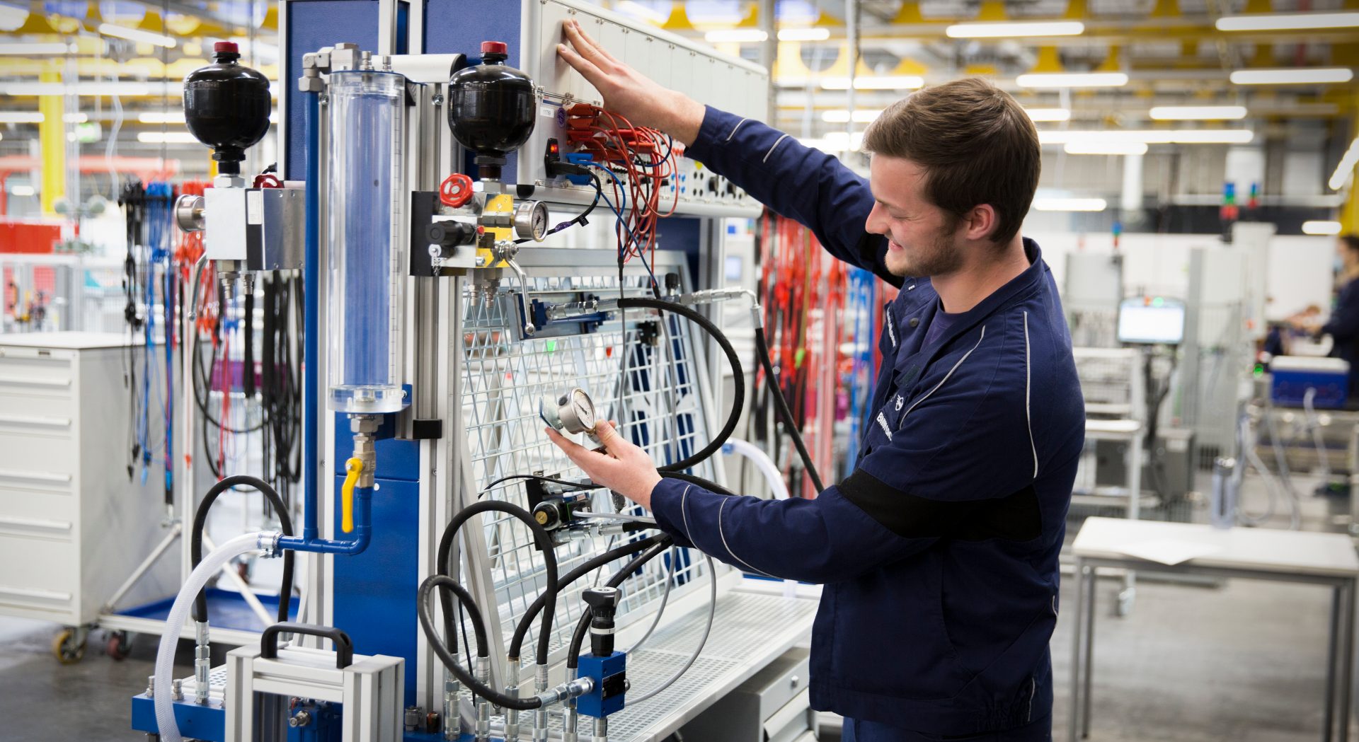 Auszubildender zum Elektroniker für Automatisierung bei der BMW Group arbeitet an einer Maschine.