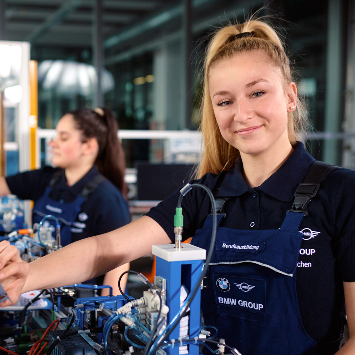 Zwei Auszubildende zu Elektronikerinnen für Automatisierung bei der BMW Group in Aktion.