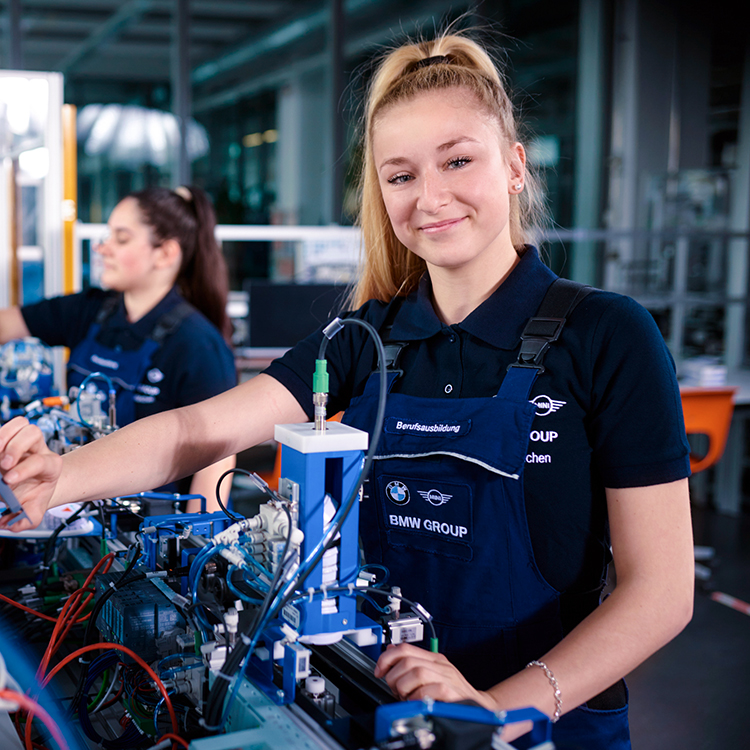 Zwei Auszubildende zu Elektronikerinnen für Automatisierung bei der BMW Group in Aktion.