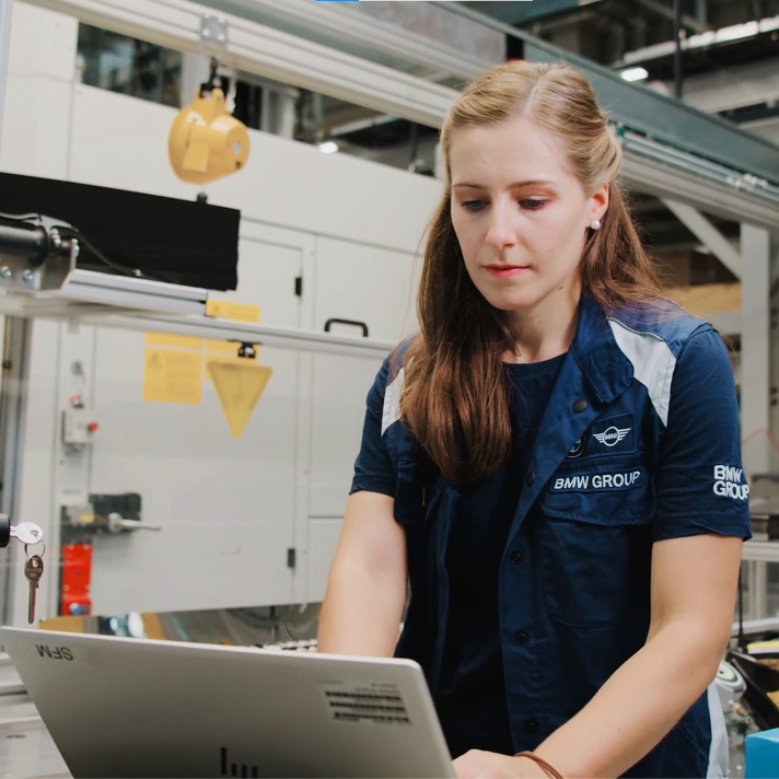 Eine Spezialistin für Instandhaltung bei der BMW Group arbeitet an einem Computer.