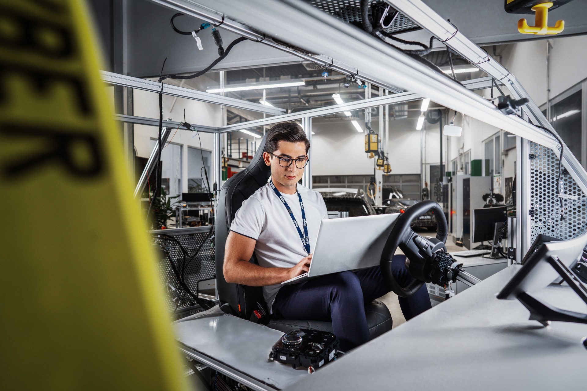 Auszubildender IT-Techniker mit Laptop in einem BMW-Ingenieurbüro.