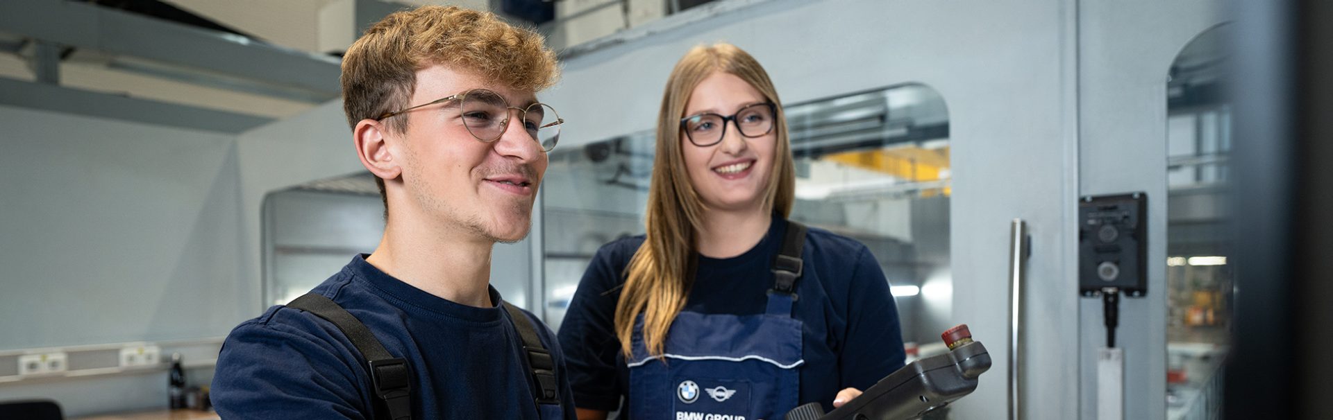 Zwei Mechatronik-Azubis bei der Arbeit an einer Maschine.