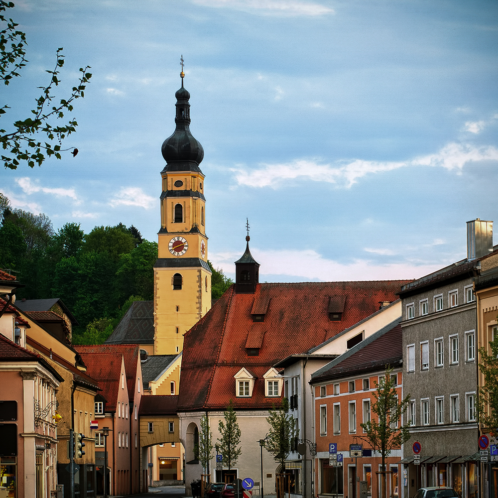 Ein Kirchturm in Dingolfing bei schönem Wetter.