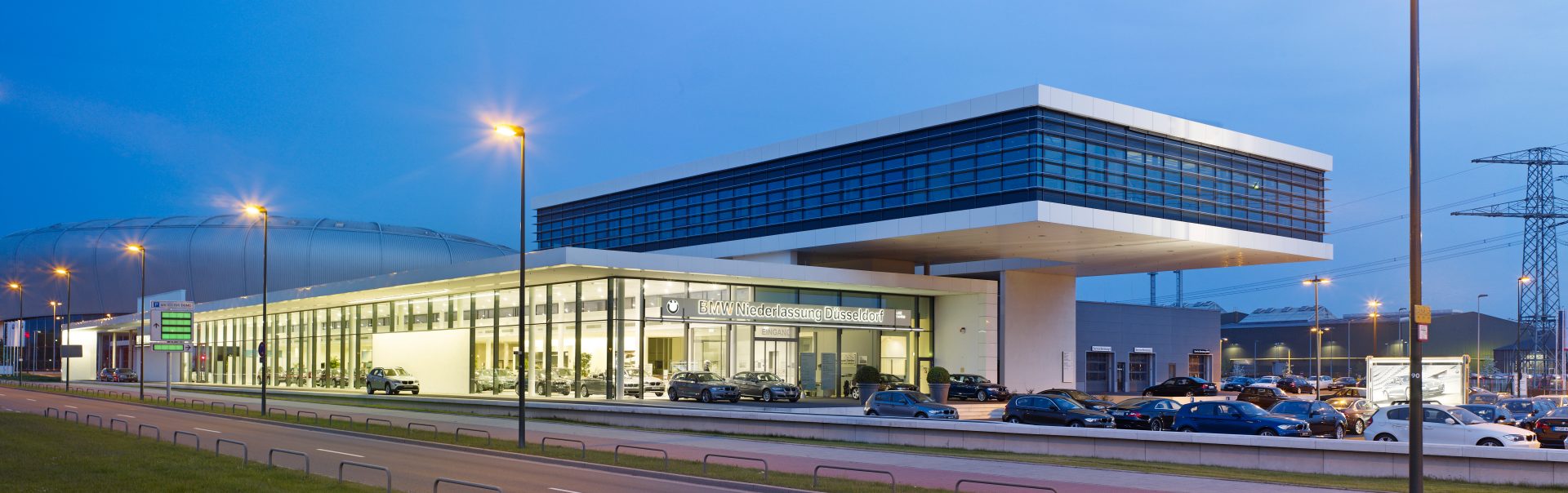 Aussenansicht der modernen BMW und MINI Niederlassung Düsseldorf bei Dämmerung.