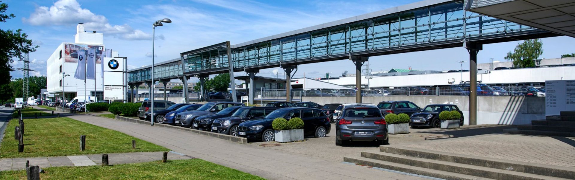 Parkplatzansicht der BMW und MINI Niederlassung in Hamburg mit mehreren Fahrzeugen.