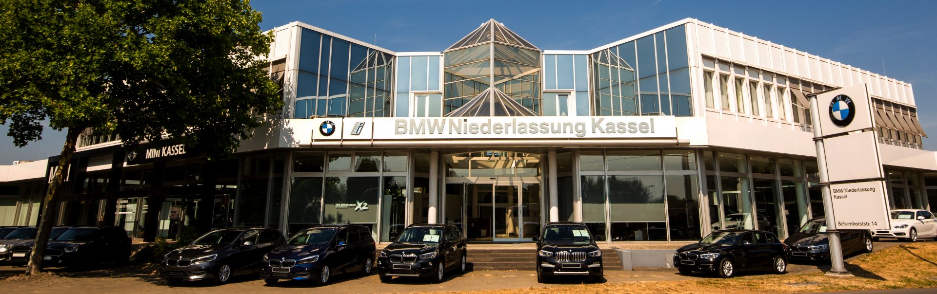 Außenansicht der BMW und MINI Niederlassung in Kassel mit mehreren Fahrzeugen.