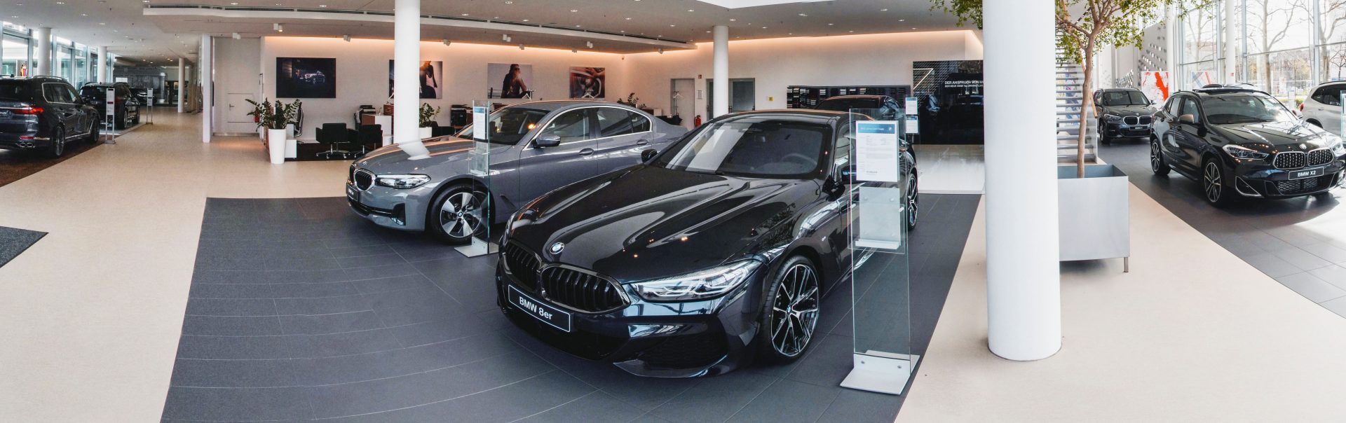 Innenansicht der BMW Niederlassung Saarbrücken mit verschiedenen Auto Modellen.