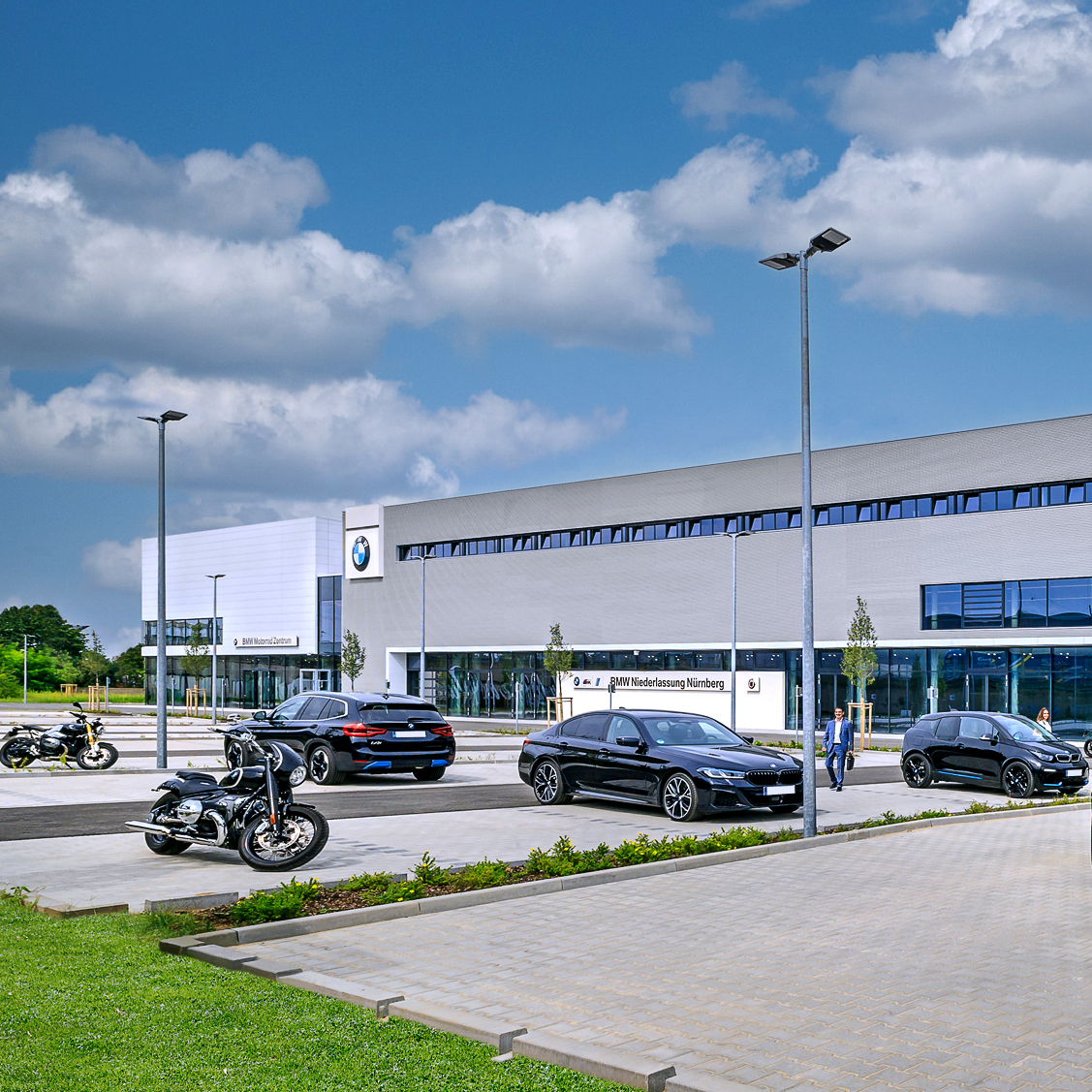 Außenansicht der BMW Niederlassung Nürnberg mit mehreren Autos und Motorrädern.