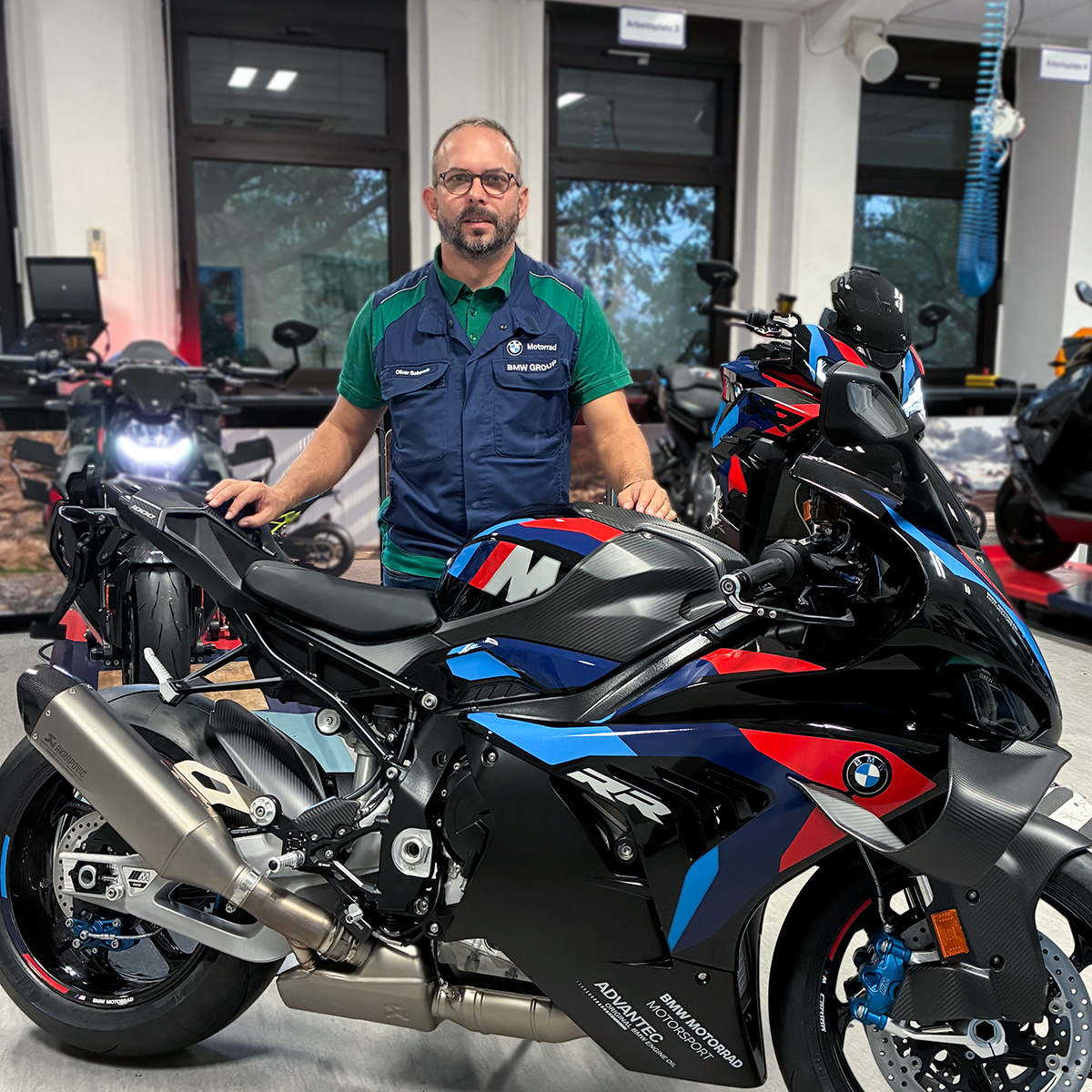Ausbilder Oliver steht hinter einem BMW Motorrad
