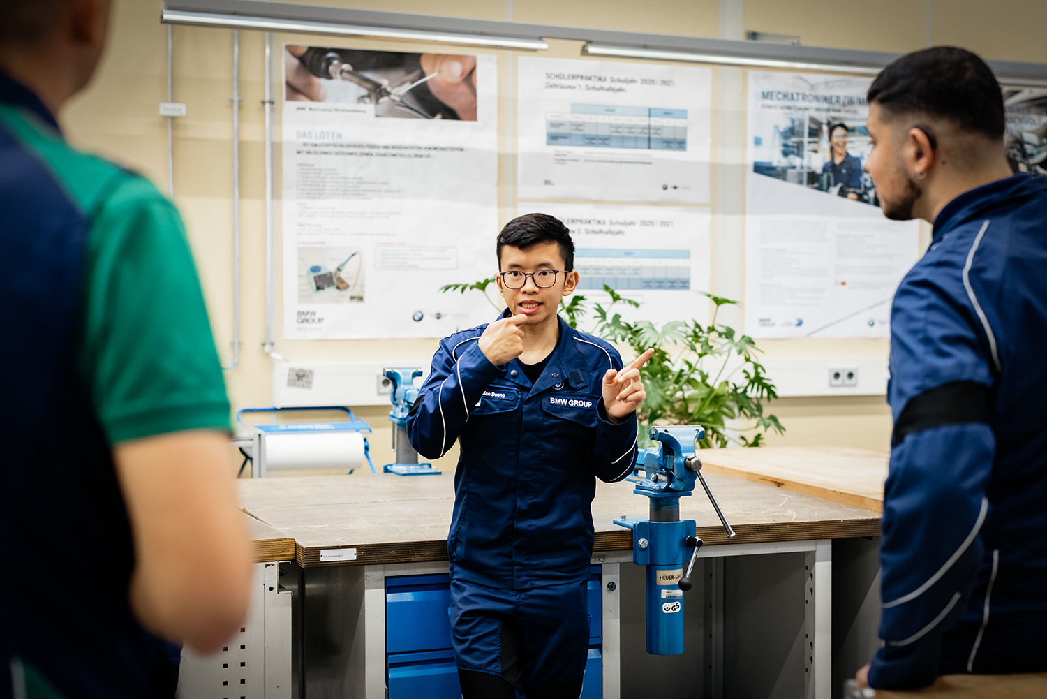 Ein gehörloser Azubi unterhält sich in Gebärdensprache mit zwei weiteren Personen