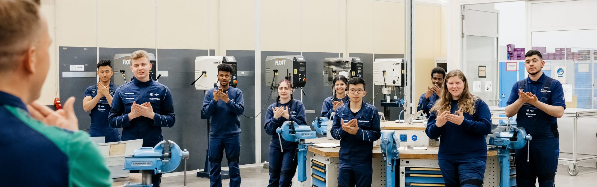Junge BMW Auszubildende die ein Gehörlosentraining bekommen.