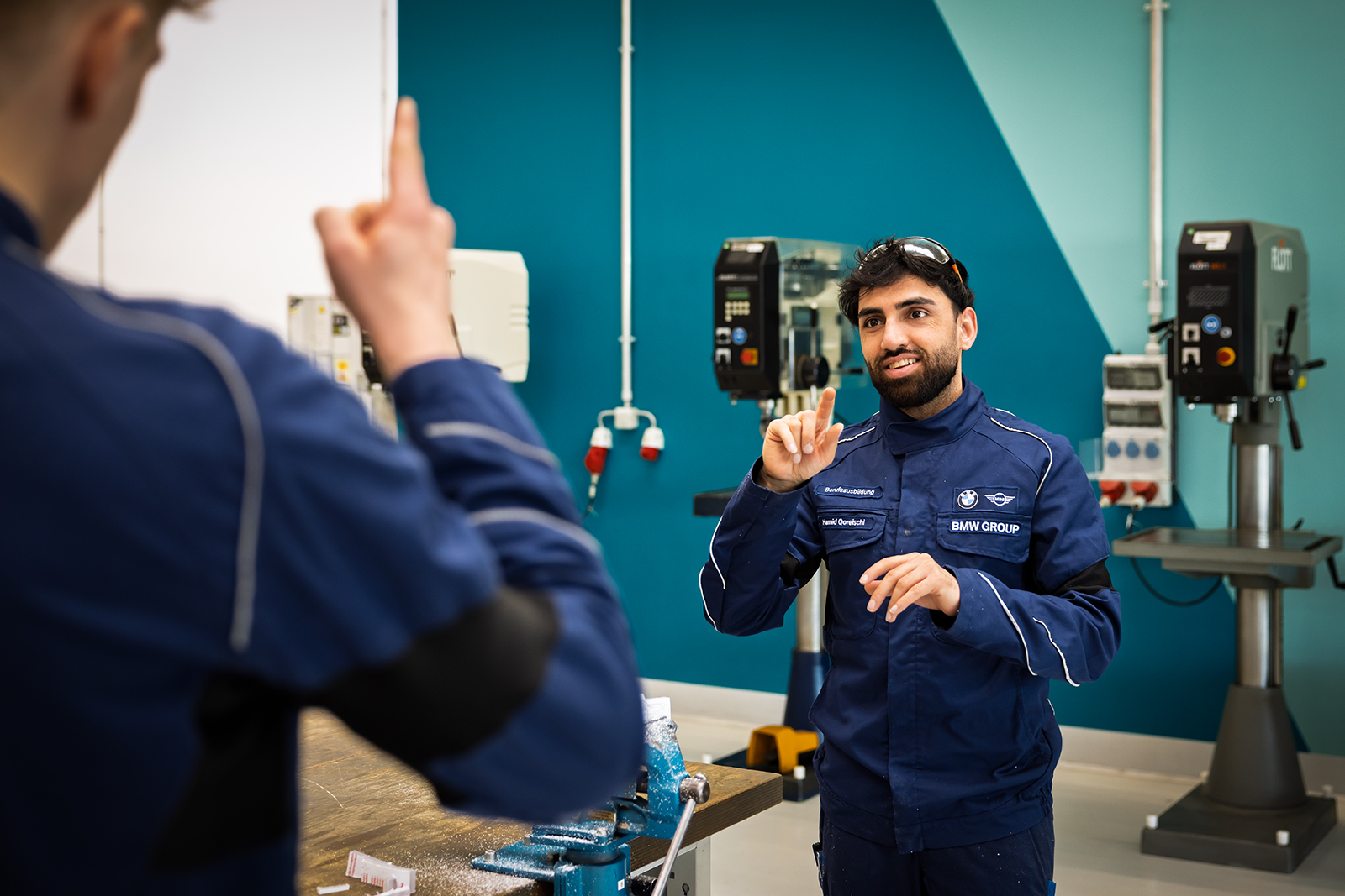 Ein gehörloser Azubi unterhält sich in Gebärdensprache mt einer weiteren Person