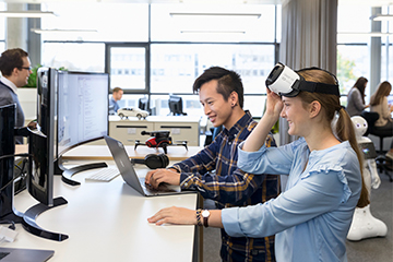 Zwei Studenten arbeiten zusammen in einem Büro mit einer VR-Brille.