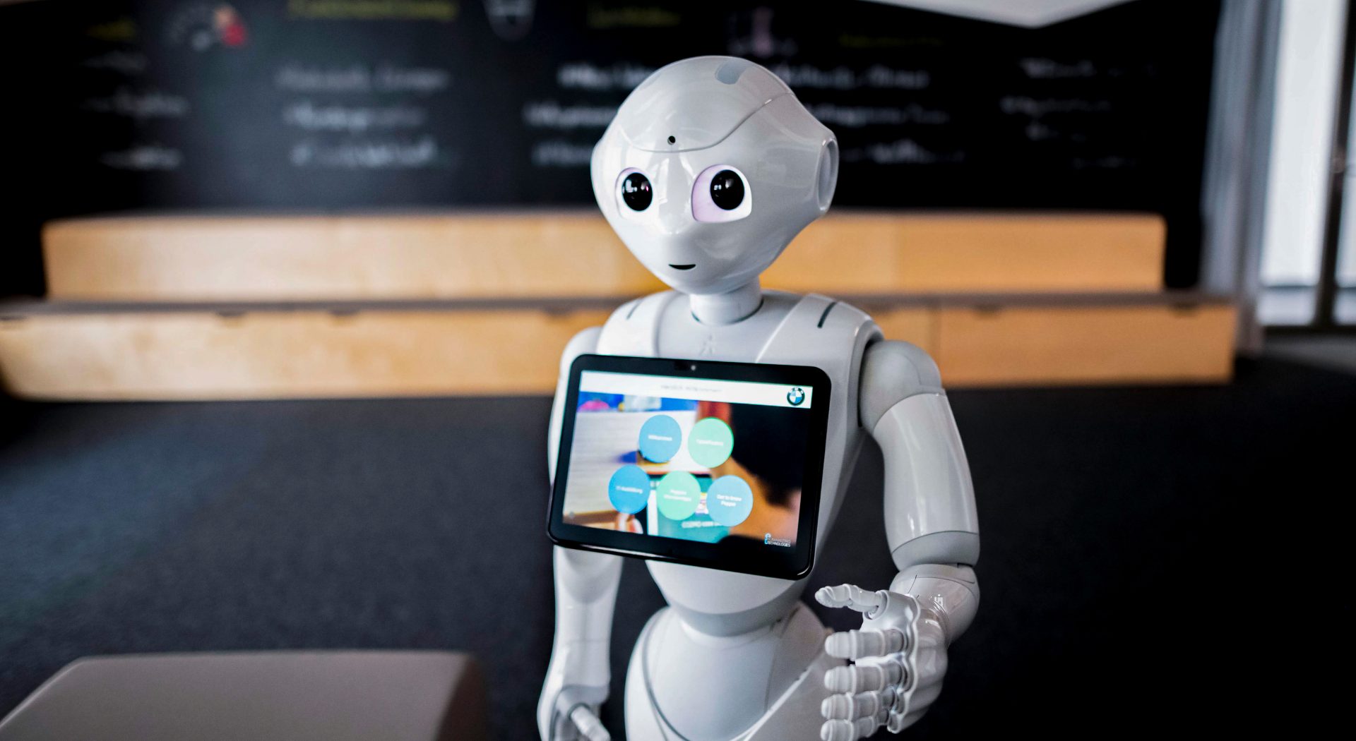 Ein Ausbildungsroboter bei der BMW Group mit einem Bildschirm bringt den Studenten etwas bei.