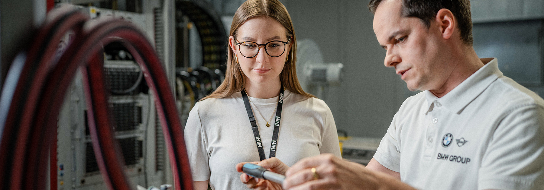 Eine duale Studentin und ihr Ausbilder bei der Arbeit an Elektronik