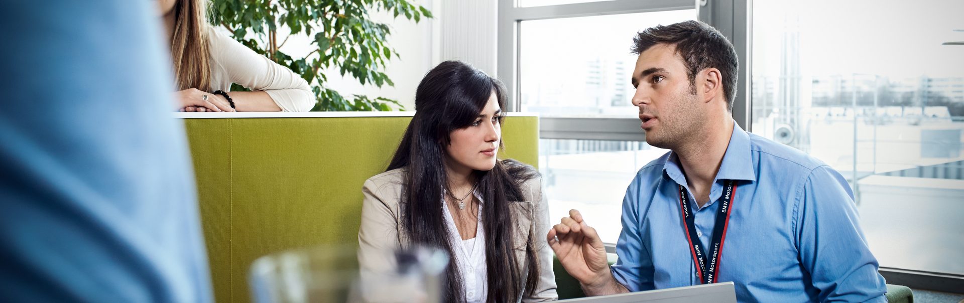 Geschäftliches Gespräch zwischen zwei Mitarbeitern in einem Büro bei der BMW Group.
