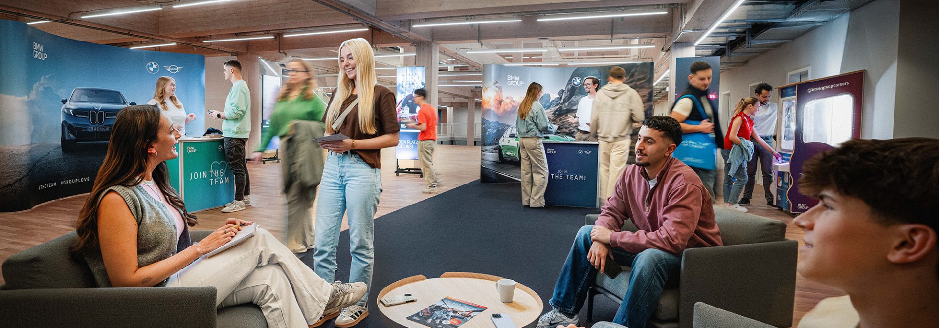 Momentaufnahme eines Events, Menschen informieren sich an verschiedenen Infoständen bei der BMW Group