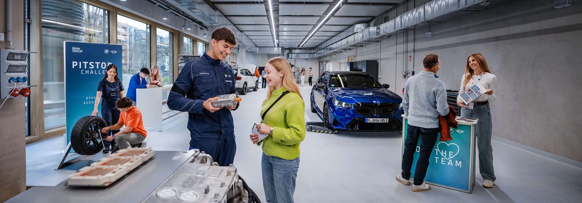 Mehrere Infostände auf dem Berufsinfotag im Talent Campus bei BMW, Menschen informieren sich über die Ausbildungsmöglichkeiten