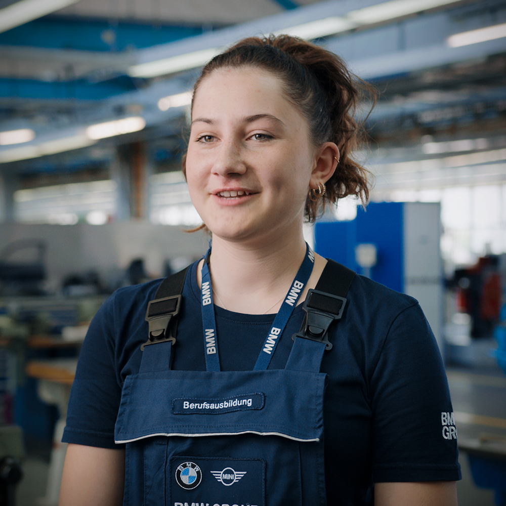 Auszubildende der BMW Group in Arbeitsklamotten.