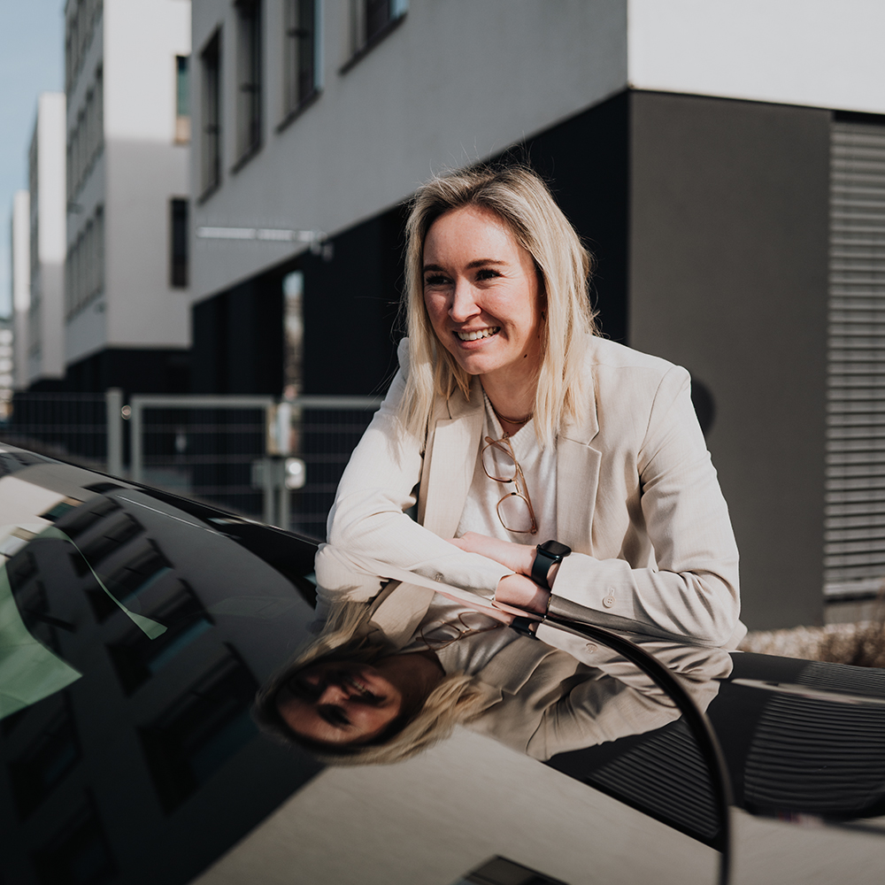 BMW Mitarbeiterin Alexandra lehnt am Heck eines BMW M4