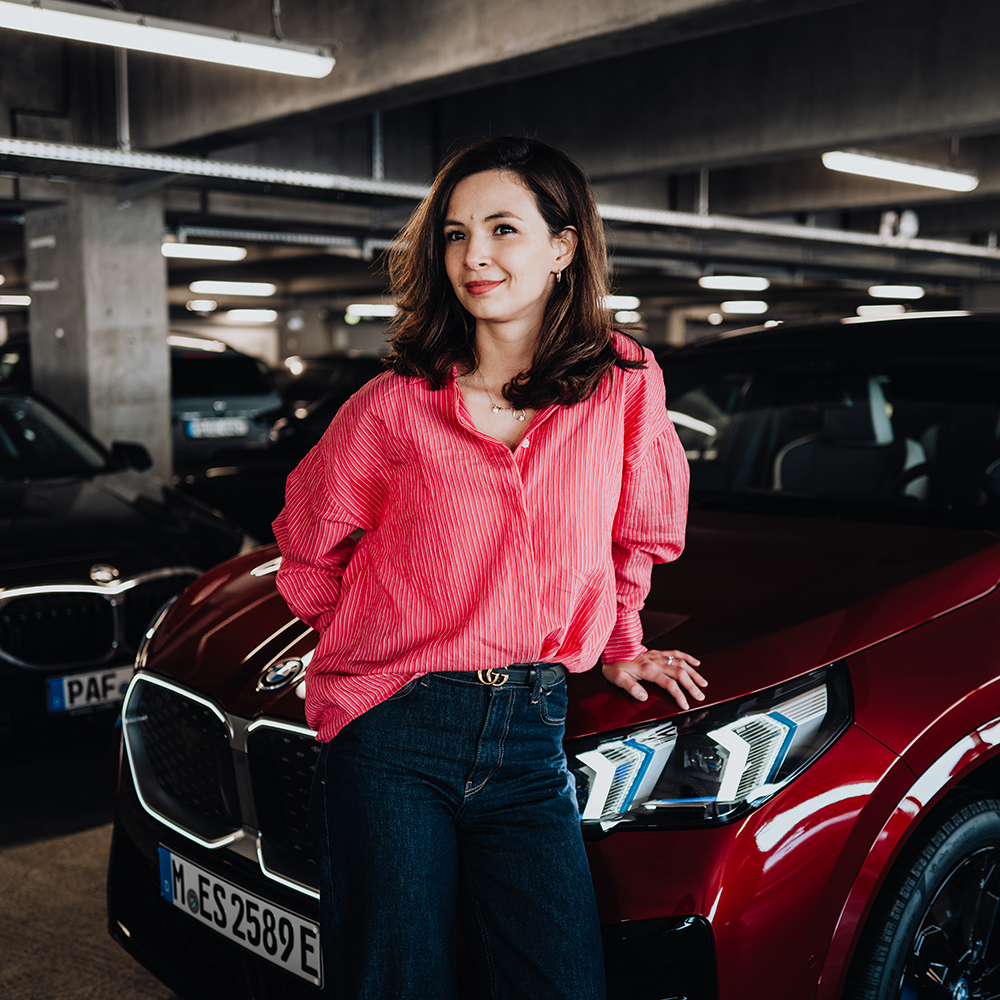 BMW Data Hub Spezialistin Denise vor einem roten BMW X2