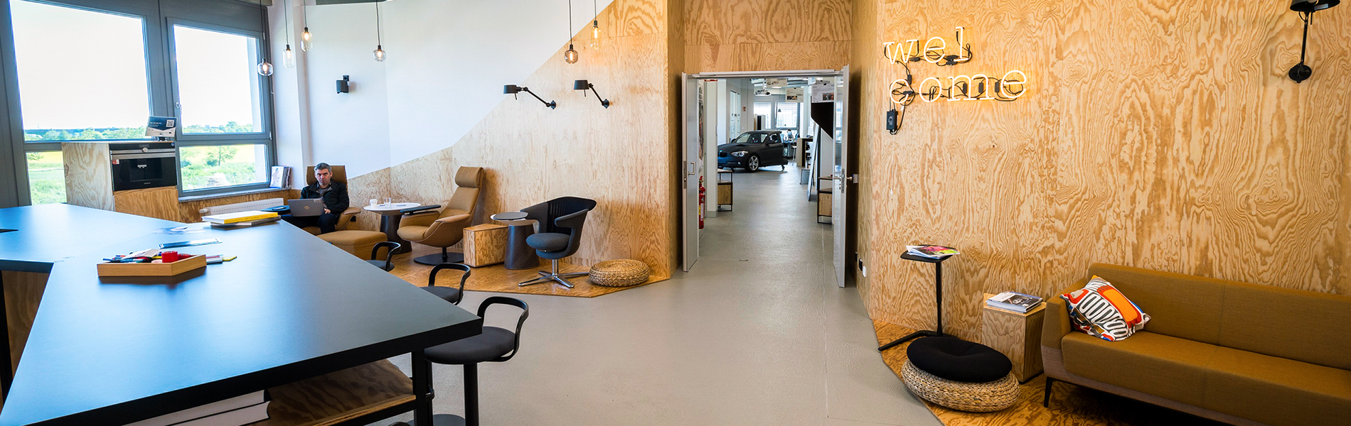 BMW Innovation Lab mit einer Holzwand mit einem 'welcome' Neonschild an der Wand