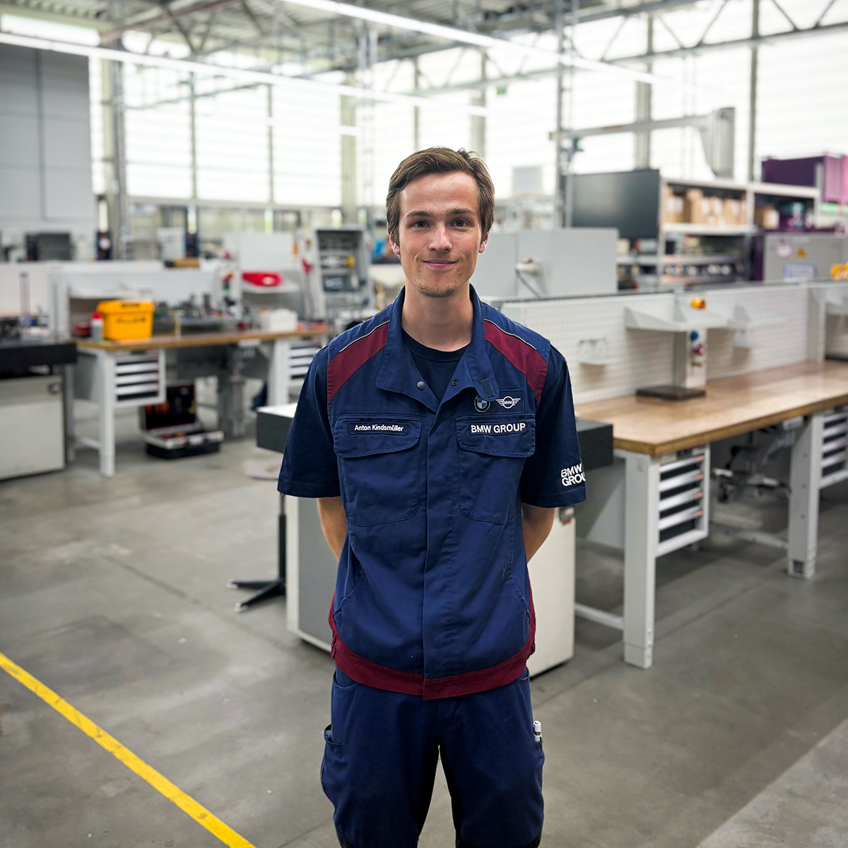 Zerspannungsmechaniker Christoph steht auf einer Treppe.