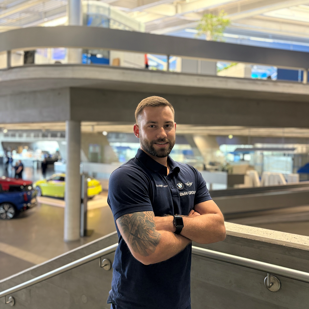 Portrait von Zerspanungsmechaniker Christoph auf einer Treppe im Werk Leipzig