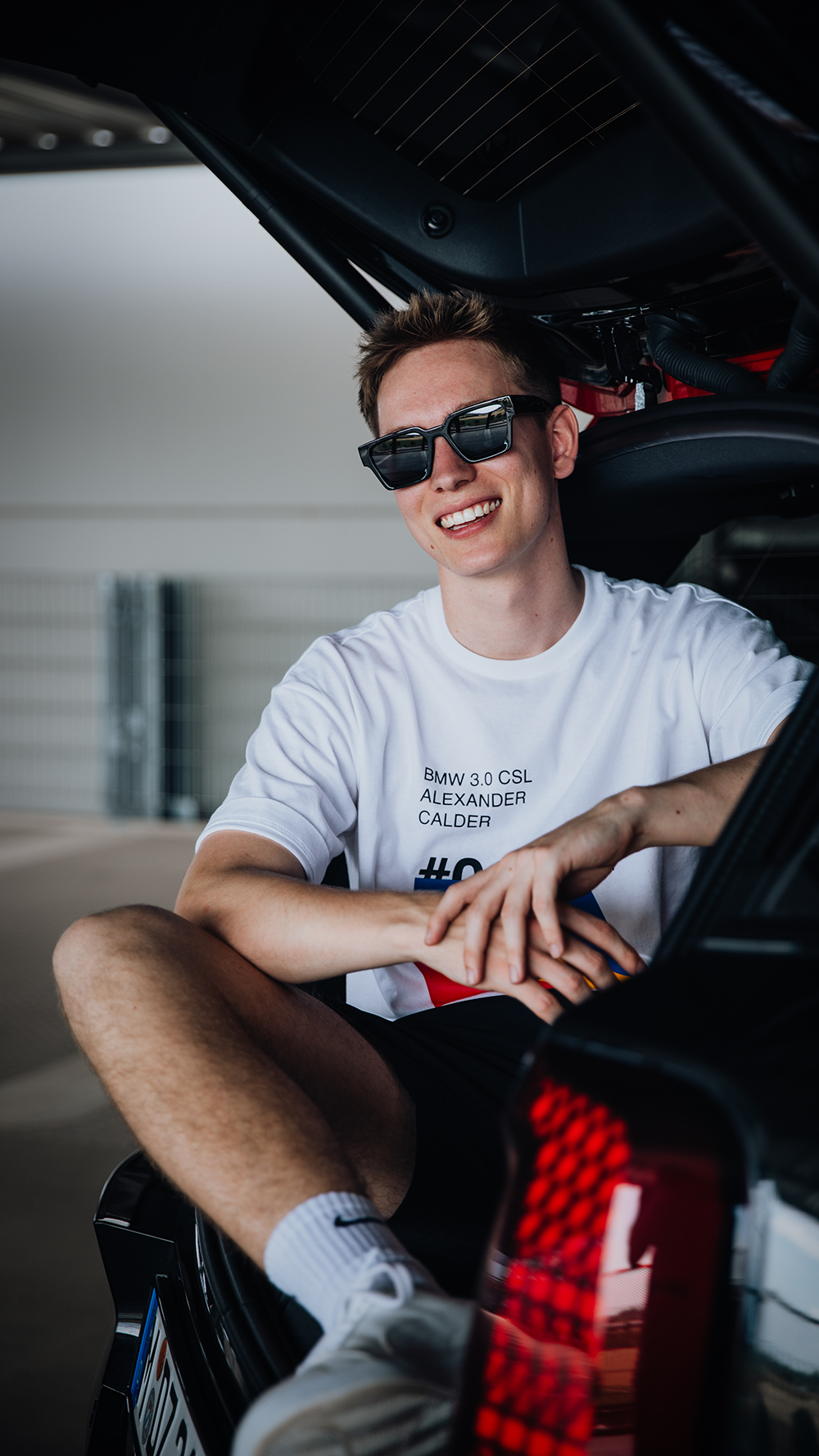 Fastlane Stipendiat sitzt im Kofferraum eines MINI Countryman