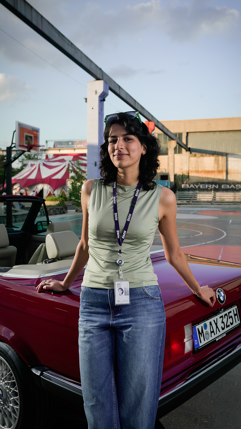 Praktikantin lehnt an einem BMW E30 Cabrio