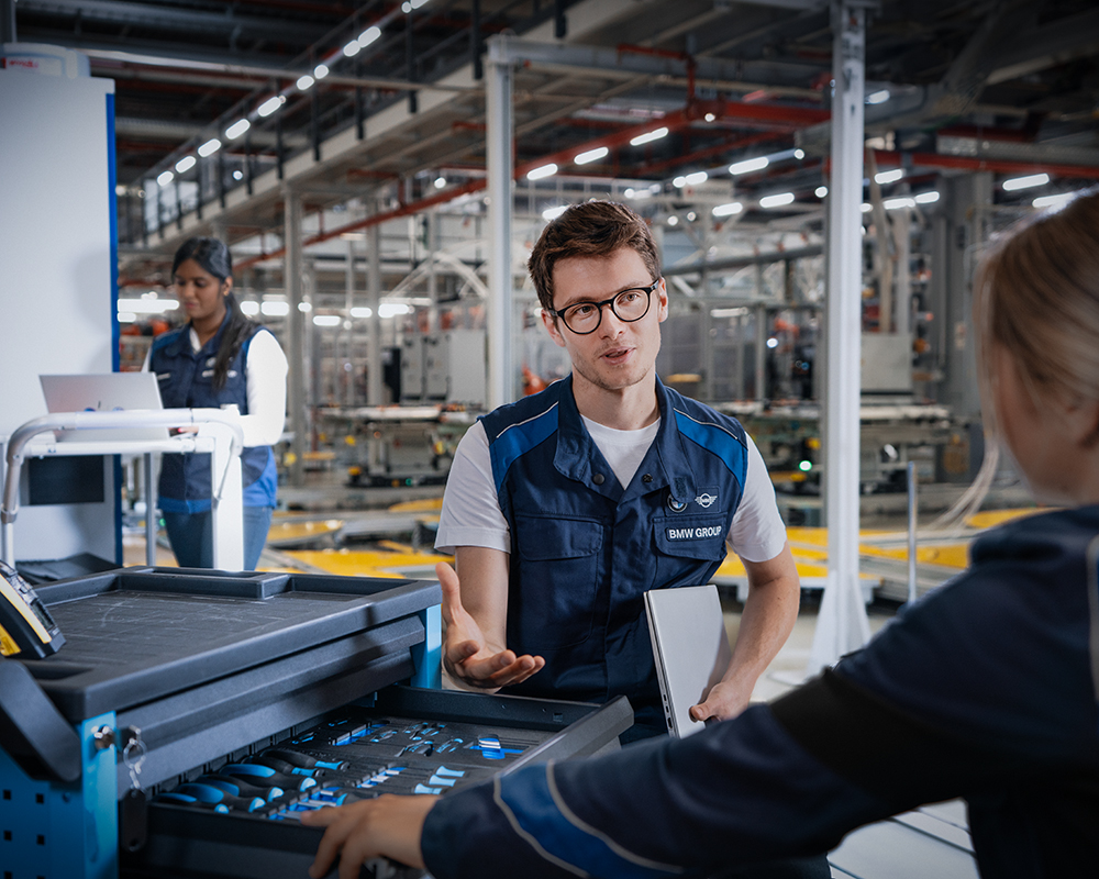 Eine Werkstudentin bei der BMW Group, die sich mit ihrem Betreuer unterhält.